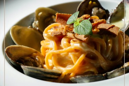 Spaghettone chilli con crema all'aglio, vongole extra e bottarga di tonno